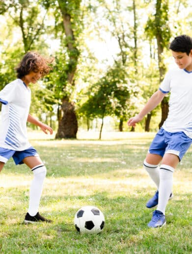 enfants-jouant-au-football-exterieur